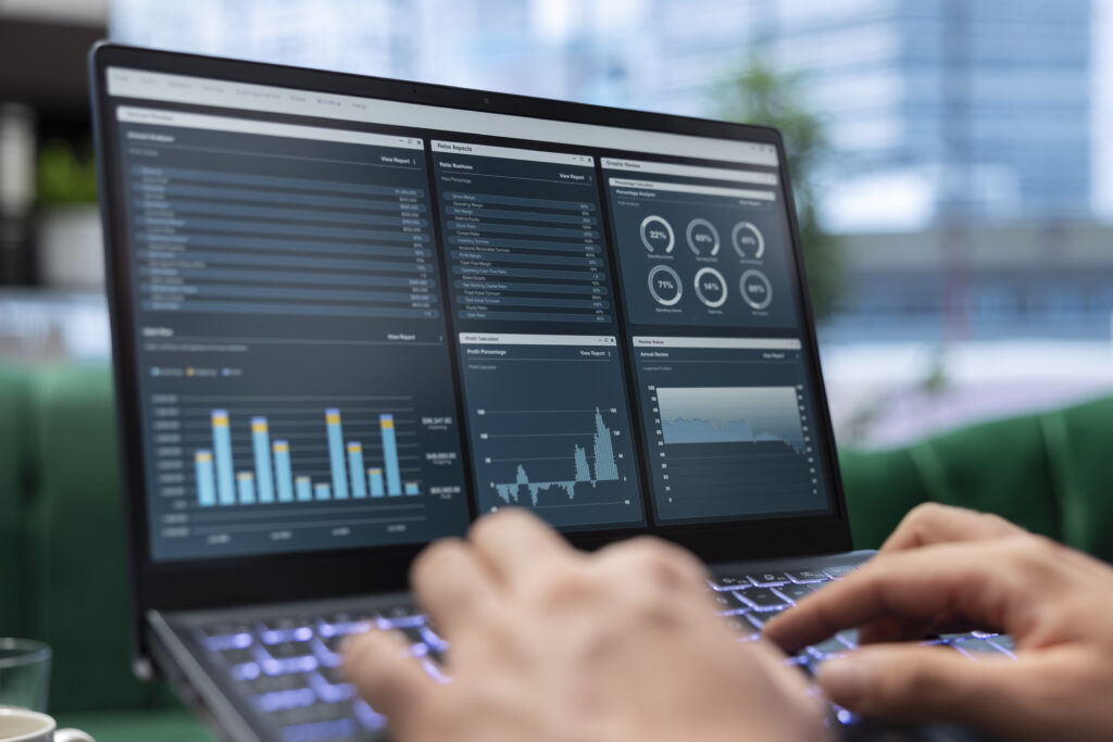 Business professional analyzing AI performance metrics and ROI data on laptop dashboard