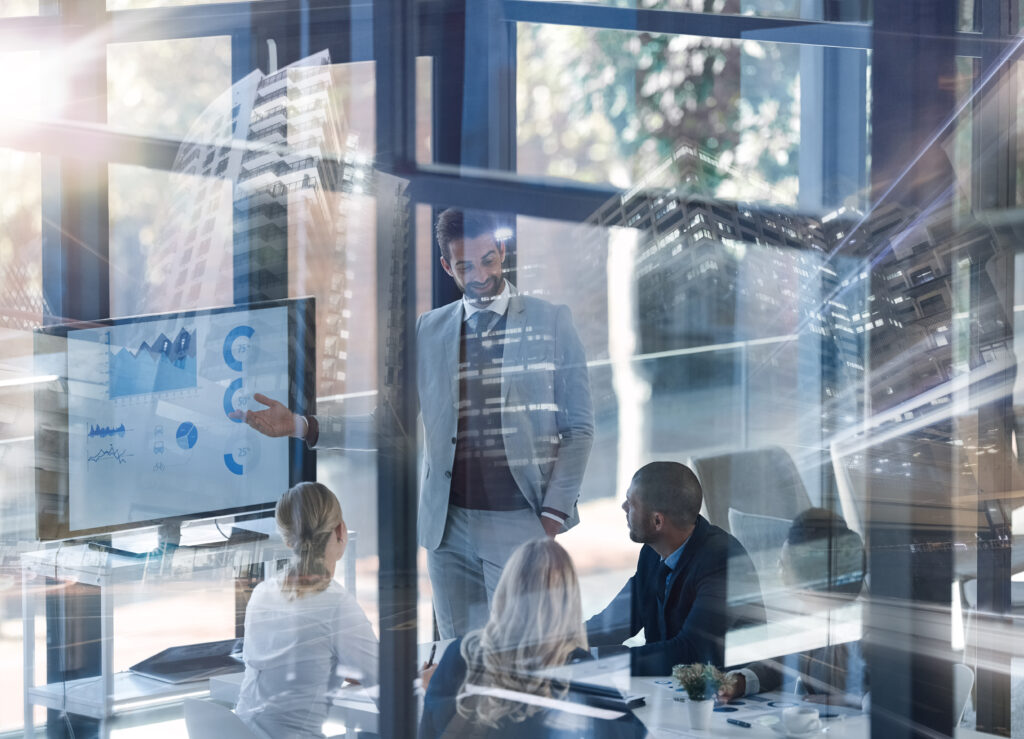 Business professionals meeting in a modern office to review data analytics and discuss AI-driven business strategy and digital transformation initiatives.